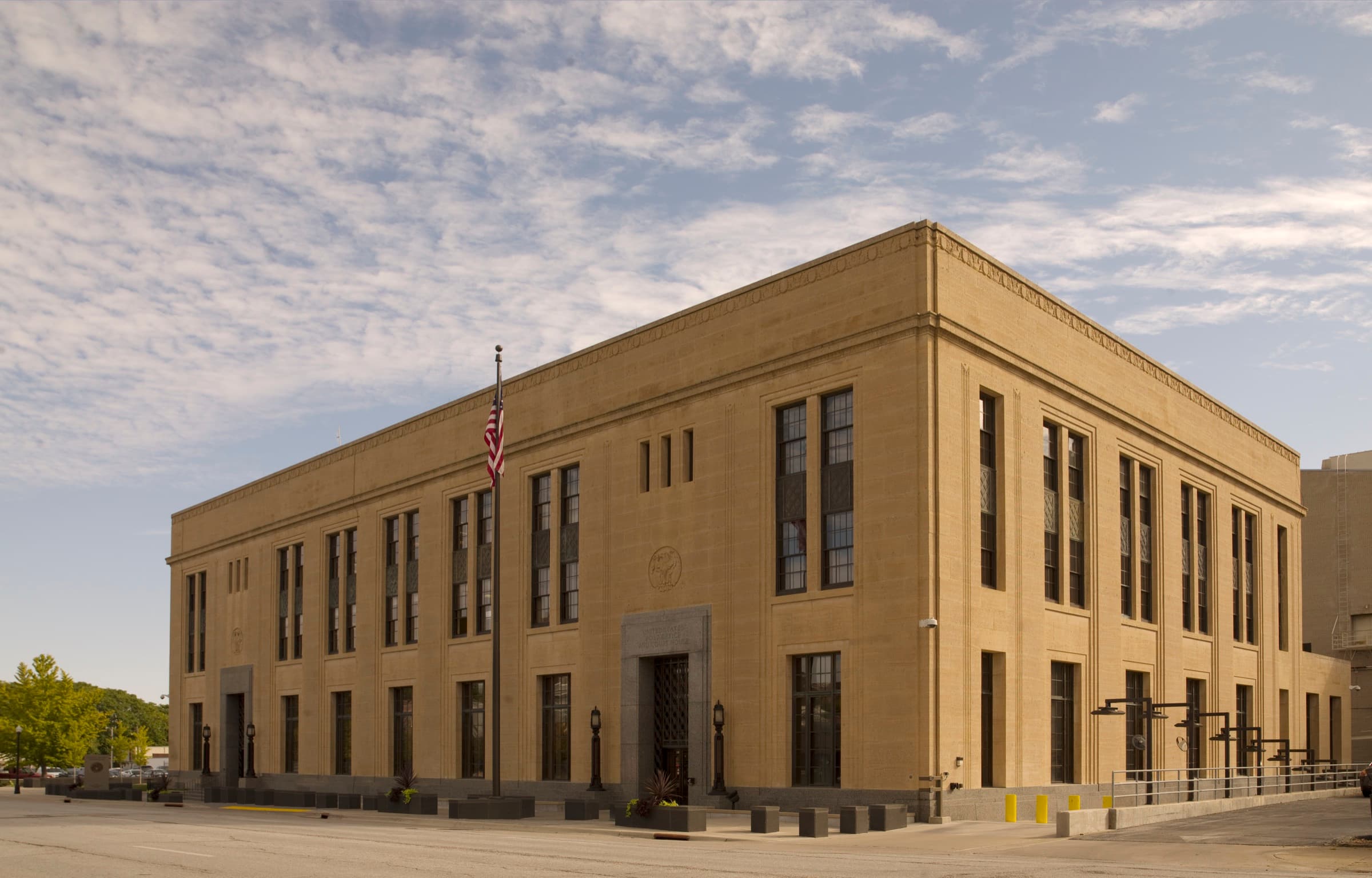 The full exterior of a United States courthouse under a bright sky
